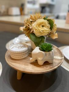 a vase of yellow flowers on a wooden plate at Penthouse suite at Holiday Hills Book today in Branson