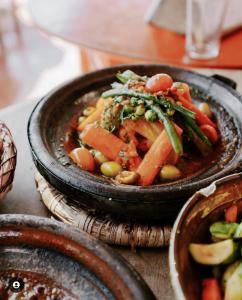 uma tigela de comida com feijão e legumes numa mesa em Riad Musa em Marrakech