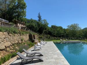 a row of chairs sitting next to a swimming pool at Estia - In Parulia Country House in Arezzo