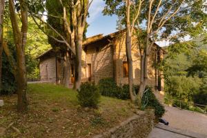 una casa de piedra con árboles delante de ella en Estia - In Parulia Country House, en Arezzo