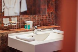 a white sink in a bathroom with a mirror at L`Art Hotel Carei in Carei