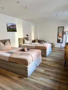 two beds in a room with wooden floors at Gästehaus Glücksmoment in Erfurt