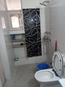 a bathroom with a toilet and a shower and a sink at Chandigarh home in Chandīgarh