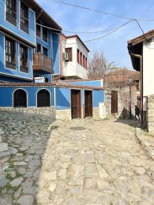 a blue building sitting next to a stone street at Old Town Stylish Flat in Center Plovdiv in Plovdiv