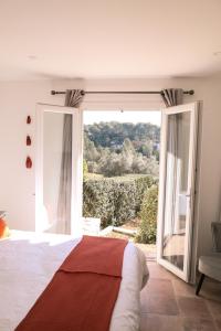 1 dormitorio con cama y ventana grande en Le Clos Serein, en Le Beausset