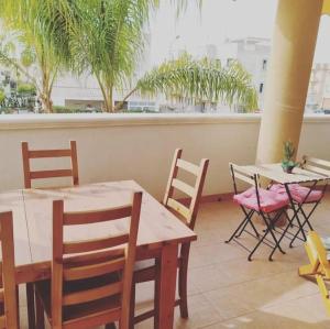 a restaurant with tables and chairs and palm trees at Casa Vacanze "LA TERRAZZA" in Leporano