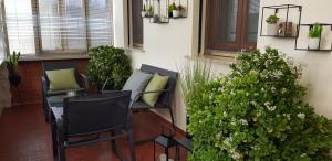 een veranda met 2 stoelen en een tafel en planten bij Casa Lola in Cavallino-Treporti