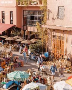 um grupo de pessoas andando em torno de um mercado ao ar livre em Riad Musa em Marraquexe