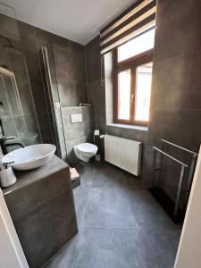 a bathroom with a sink and a toilet and a window at Gästehaus Glücksmoment in Erfurt +24 photos