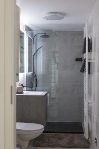 a bathroom with a shower and a toilet and a sink at Modern City Apartment in Graz