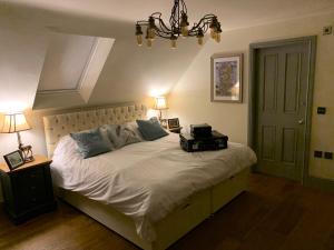 a bedroom with a bed with a suitcase on it at Luxury Boutique Country Cottage with Hot Tub in York