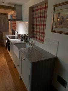 a kitchen with a sink and a counter top at Luxury Boutique Country Cottage with Hot Tub in York