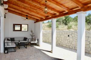 a patio with a stone wall and a wooden ceiling at Villa Bora - Blue Flat Green Flat in Slatine