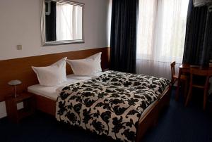 een slaapkamer met een bed met een zwart-witte deken bij Pension ABC in Berlijn