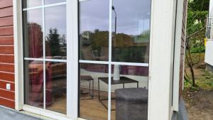 une fenêtre d'une maison avec une table et une chaise dans l'établissement Tiny House Strandwagen mit Terrasse, à Ahlbeck
