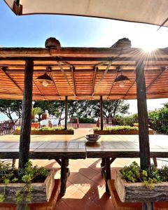 a picnic table with a wooden umbrella on a patio at B&B Iolì Vesuvio in Ercolano