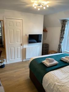 a bedroom with a bed with two towels on it at The Claymore Guest House and Apartments in Pitlochry