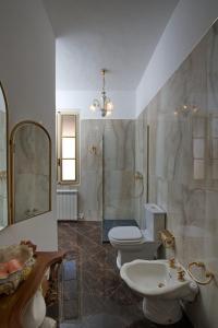 y baño con 2 aseos, lavamanos y ducha. en Villa Albaluce, en Caluso