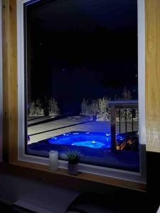 a window with a view of a swimming pool at night at Sable Point Cottage (Lakeside 7-Person Hot Tub & Outdoor Shower) in Grand River