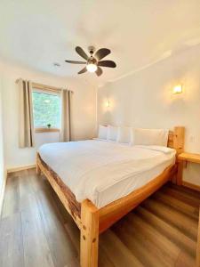 - une chambre avec un lit et un ventilateur de plafond dans l'établissement Sable Point Cottage (Lakeside 7-Person Hot Tub & Outdoor Shower), à Grand River