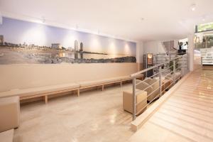 una sala de espera con bancos y una pared con una imagen en Hostal Centric en Barcelona