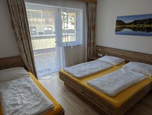 two beds in a room with a window at Appartements Gotthardt in Flachau