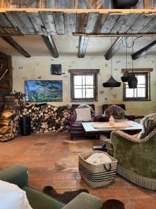 a living room with couches and a table and logs at Chalet Burja at Vogel mountain - cable car access or hiking - not reachable with car in Bohinj