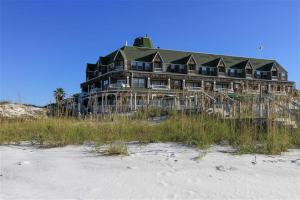a large building on the beach with tall grass at Henderson Park Inn in Destin