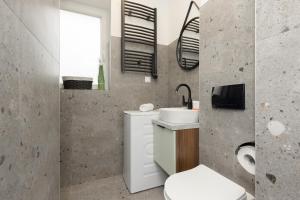 Łazienka z białą toaletą i umywalką w obiekcie Cozy Studio Apartment Kolorowa Warsaw Ursus by Renters w Warszawie