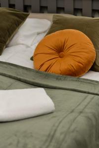 pomarańczowa poduszka na 2 łóżkach w obiekcie Cozy Studio Apartment Kolorowa Warsaw Ursus by Renters w Warszawie