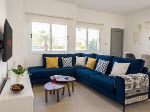 a blue couch in a living room with a table at Ayia Napa Holiday Villa 040 in Ayia Napa