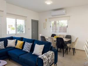 un soggiorno con divano blu e tavolo di Ayia Napa Holiday Villa 040 a Ayia Napa