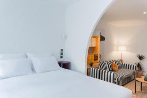 um quarto com uma cama branca e um sofá em MadaM Apartments - elegant, cozy, comfortable, central em Ioannina