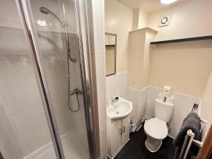 La salle de bains est pourvue d'une douche, de toilettes et d'un lavabo. dans l'établissement The Old Post Office Public House & Hotel, à Halifax
