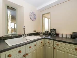 a kitchen with a sink and a mirror on the wall at Pen-Croeslan Bach in Crickhowell