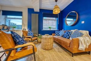 uma sala de estar com paredes azuis e um sofá e cadeiras em DUDLEY by HOSPITAL - 5 beds - PARKING - Long stay - CONTRACTORS em Dudley
