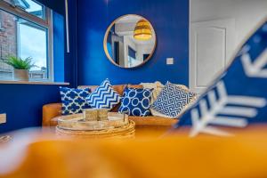 - un salon avec des murs bleus et un canapé avec des oreillers dans l'établissement DUDLEY by HOSPITAL - 5 beds - PARKING - Long stay - CONTRACTORS, à Dudley