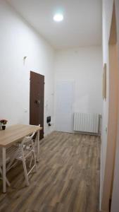 an empty room with a wooden table and a wooden floor at Casa Emilia [centro storico] in Imola