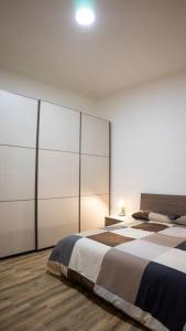 a bedroom with a large bed with white cabinets at Casa Emilia [centro storico] in Imola