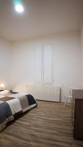 a bedroom with a bed and a large window at Casa Emilia [centro storico] in Imola