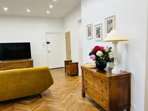 Magnifique Appartement l'Aigrette في دْييب: غرفة معيشة مع إناء من الزهور على خزانة