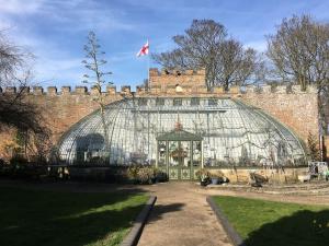 ein großes Gewächshaus aus Glas vor einem Backsteingebäude in der Unterkunft Georgian 5 storey house, seaviews, cinema room in Kent