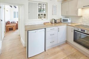 une cuisine avec des armoires blanches et des appareils électroménagers blancs dans l'établissement Host & Stay - Rose Cottage, Pickering, à Pickering