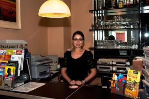 a woman standing behind a counter in a bar at Pension ABC in Berlin