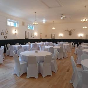 a room with white tables and white chairs at The Gordon Arms Hotel in Huntly