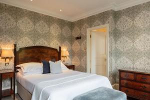 a bedroom with a large bed with white sheets at The Petersham in Richmond upon Thames