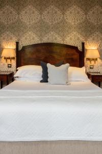 a large bed with white sheets and pillows at The Petersham in Richmond upon Thames