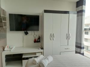 a bedroom with a tv and a bed with towels at BAMBOO APARTAMENTO MONOAMBIENTE, Equipetrol Norte - con Garaje in Santa Cruz de la Sierra