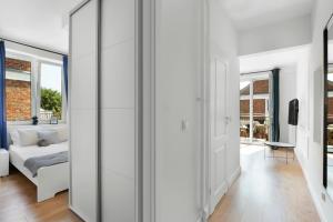 a living room with white walls and a white couch at Elite Apartments Hewelius Prestige in Gdańsk