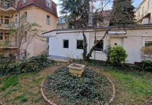 einen Hof mit einem Haus und einem Eimer im Gras in der Unterkunft Flowery House in Center in Zagreb